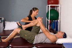 Man receiving physical therapy on knee. 